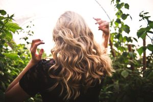 HOME Vrouw met glanzend haar onderzoekt haar lokken voor haarverzorging en het maximale uit haar haar halen
